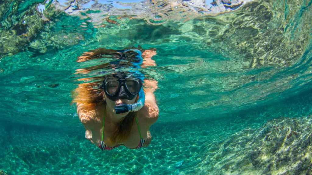 Mujer practicando snorkel en el mar.