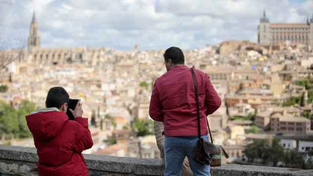 Unos turistas en las inmediaciones del Kiosco Base fotografían la panorámica de Toledo.