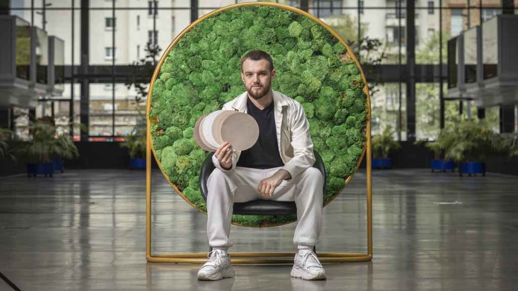 Valentyn Frechka sujetando papeles hechos con hojas de árbol caídas.