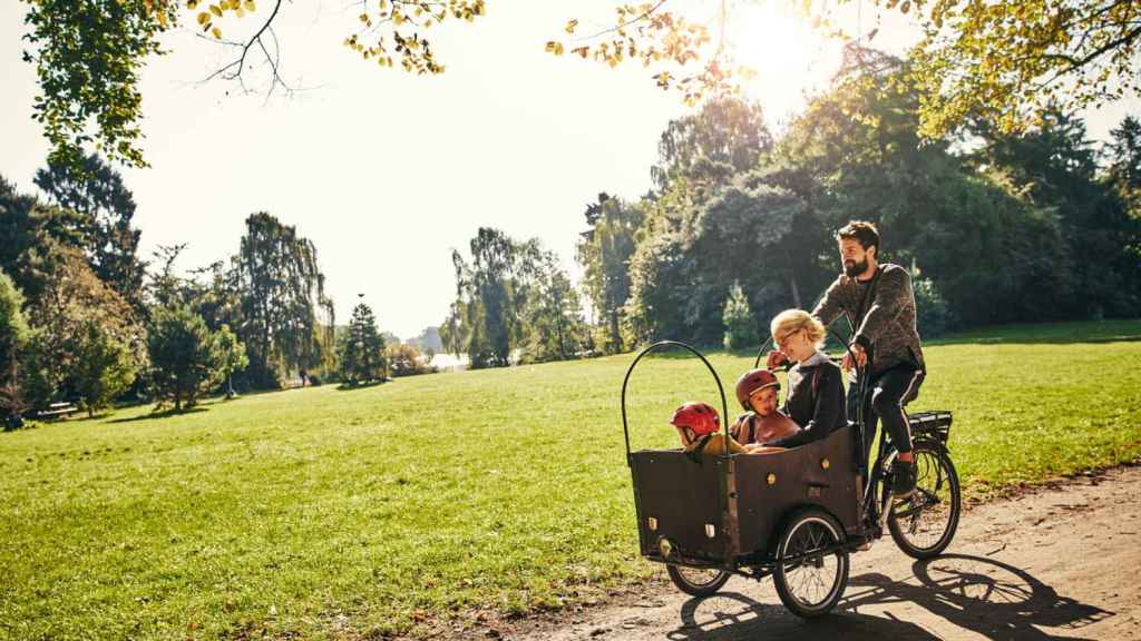 Familia en una bicicleta por el parque.