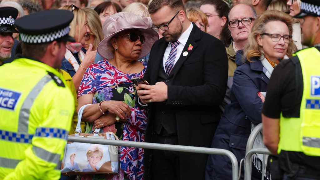 La mujer que ha acudido a la catedral con un bolso con la imagen estampada de Lady Di.