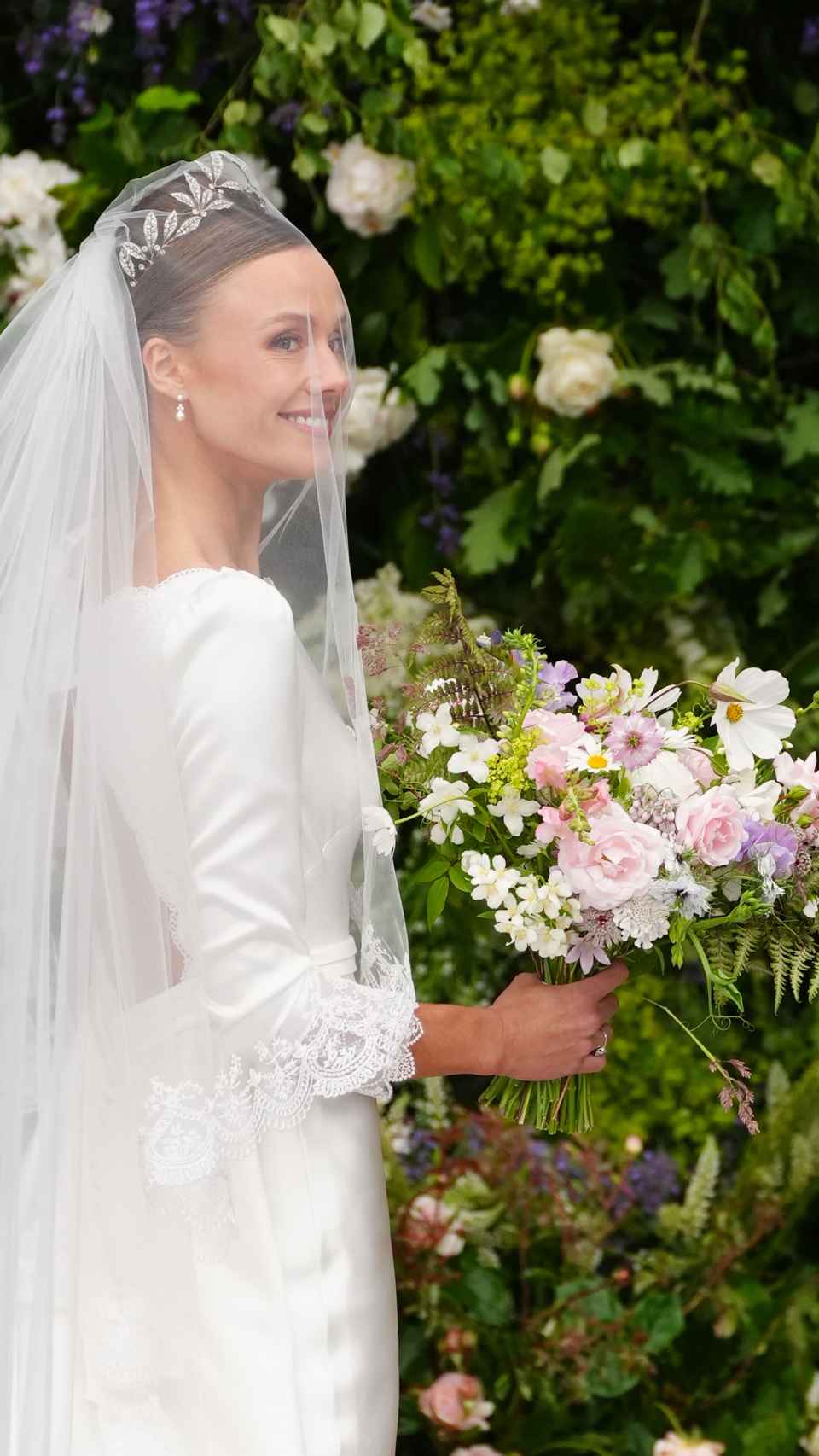 La novia, sonriente, llegando a la iglesia para darse el 'sí, quiero'.