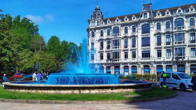 La fuente de la plaza de la Escandalera con el agua tintada del color de la bandera de Asturias.