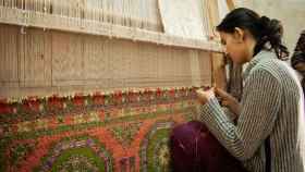 Una mujer trabajando en un telar.