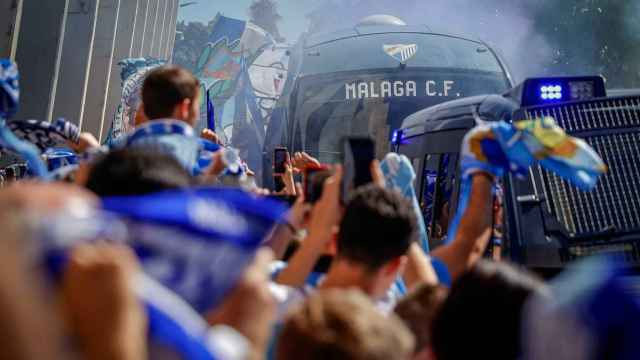 El autobús del Málaga CF en medio de un recibimiento de la afición.