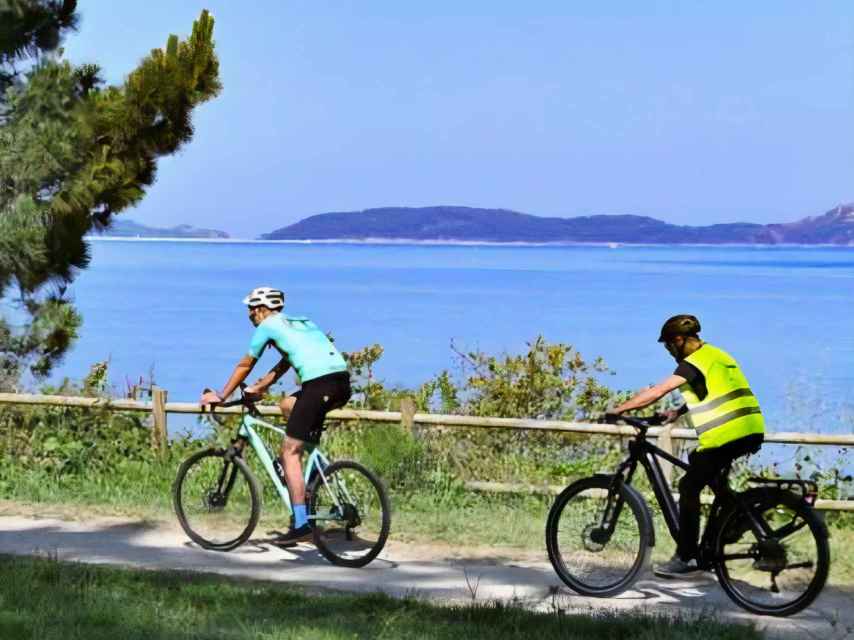 Dos ciclistas junto a la Ría de Vigo.