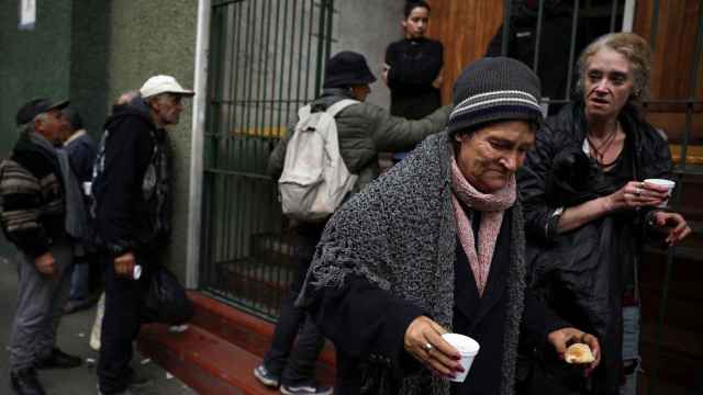Una mujer se aleja después de recibir alimentos en una iglesia que ayuda a los pobres en Buenos Aires.