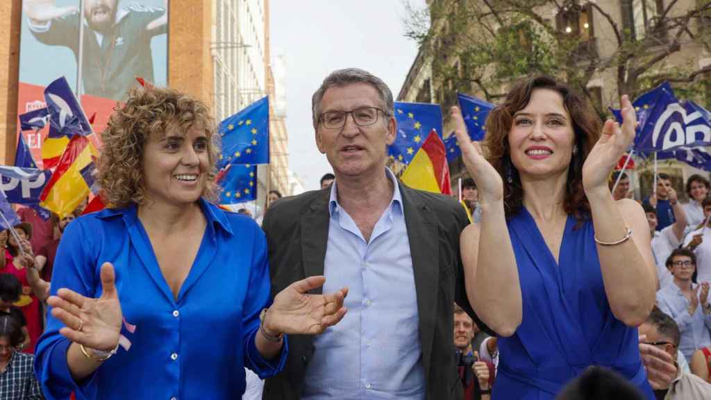 La candidata Dolors Montserrat, Alberto Núñez Feijóo e Isabel Díaz Ayuso, durante el mitin celebrado el jueves en la plaza de Callao de Madrid bajo la lluvia.