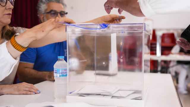 Un diputado desposita su voto en una mesa electoral del Colegio de los Maristas de Sevilla.