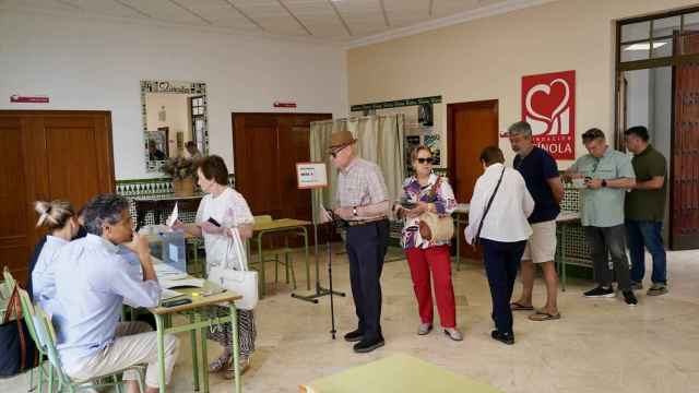 Varias personas hacen cola para votar en un colegio electoral de Málaga, este domingo.