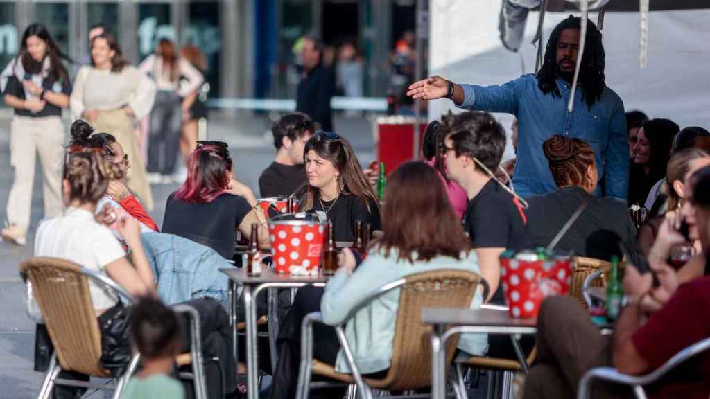 Varias personas en la terraza de un bar.