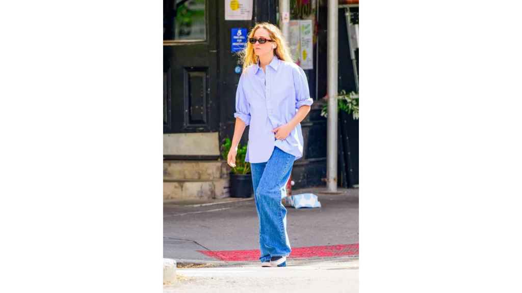 Jennifer Lawrence con pantalonnes baggy y blussa semiabierta.