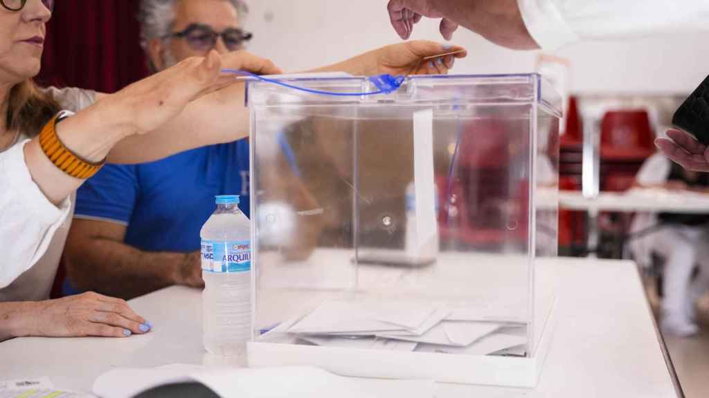 Un votante introduce su papeleta en la urna en el Colegio Maristas de Sevilla.