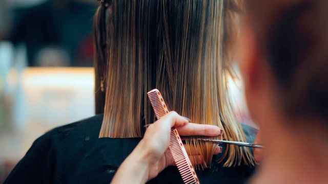 Mujer cortando el cabello en la peluquería.