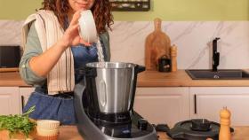 Imagen de archivo de una mujer utilizando un robot de cocina.