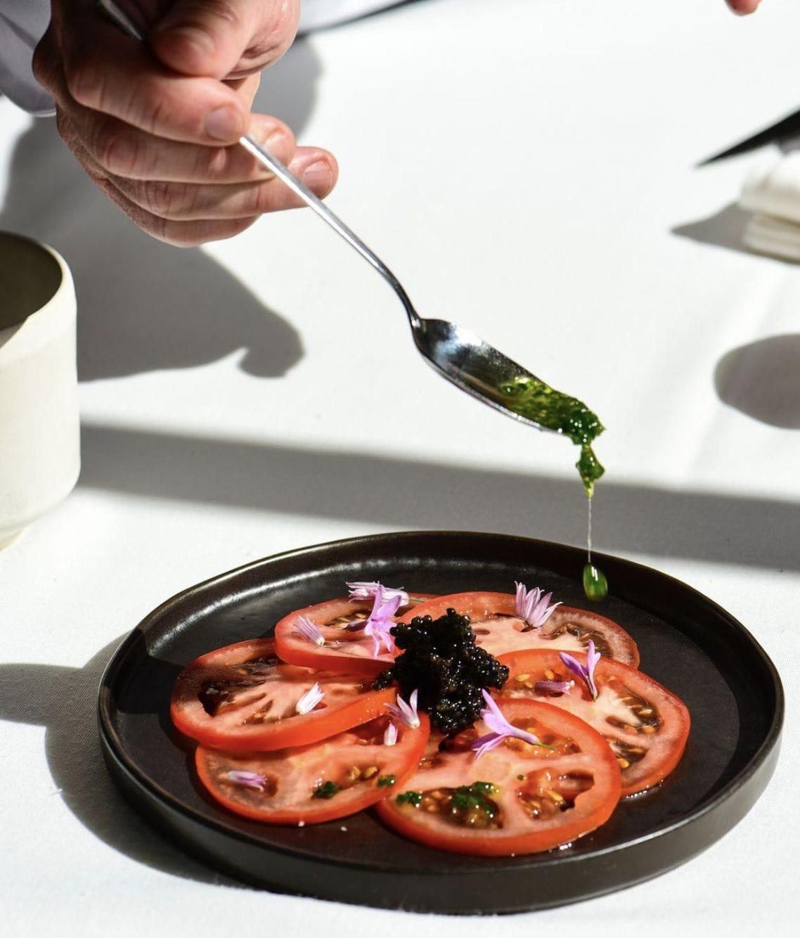 Carpaccio de tomates ecológicos con flores y caviar.