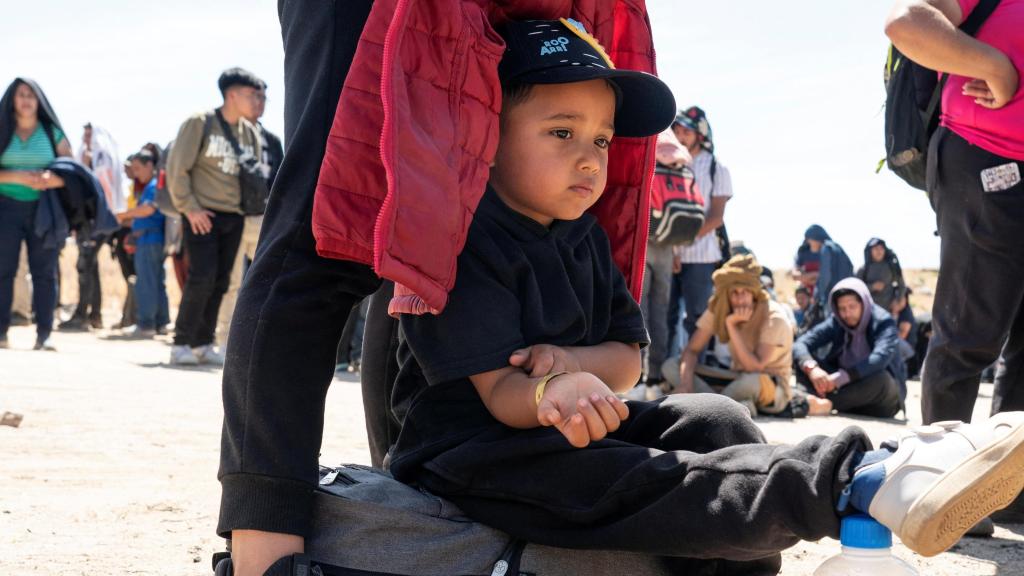 Un niño colombiano, solicitante de asilo, espera junto a su madre en la frontera sur de EEUU.