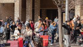 Numerosas personas hacen colas en la sede de la Fundación Madrina para recibir ayuda.