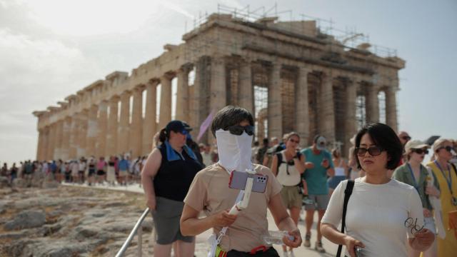 Una tropa de turistas evacúa el Partenón antes del cierre de la colina de la Acrópolis, este jueves en Atenas.