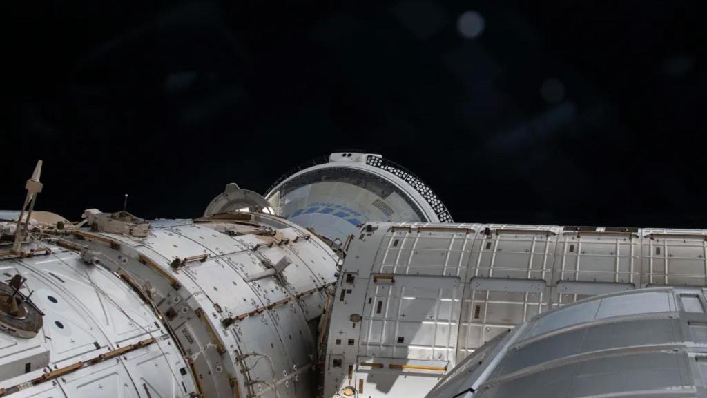 Starliner vista desde una ventana de la ISS, acoplada en el puerto delantero del módulo Harmony.