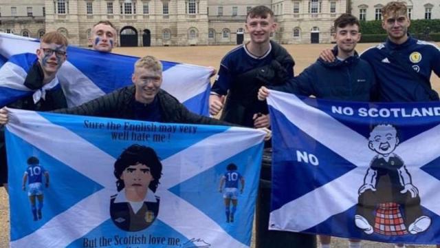 Aficionados de Escocia posan con banderas de Maradona.