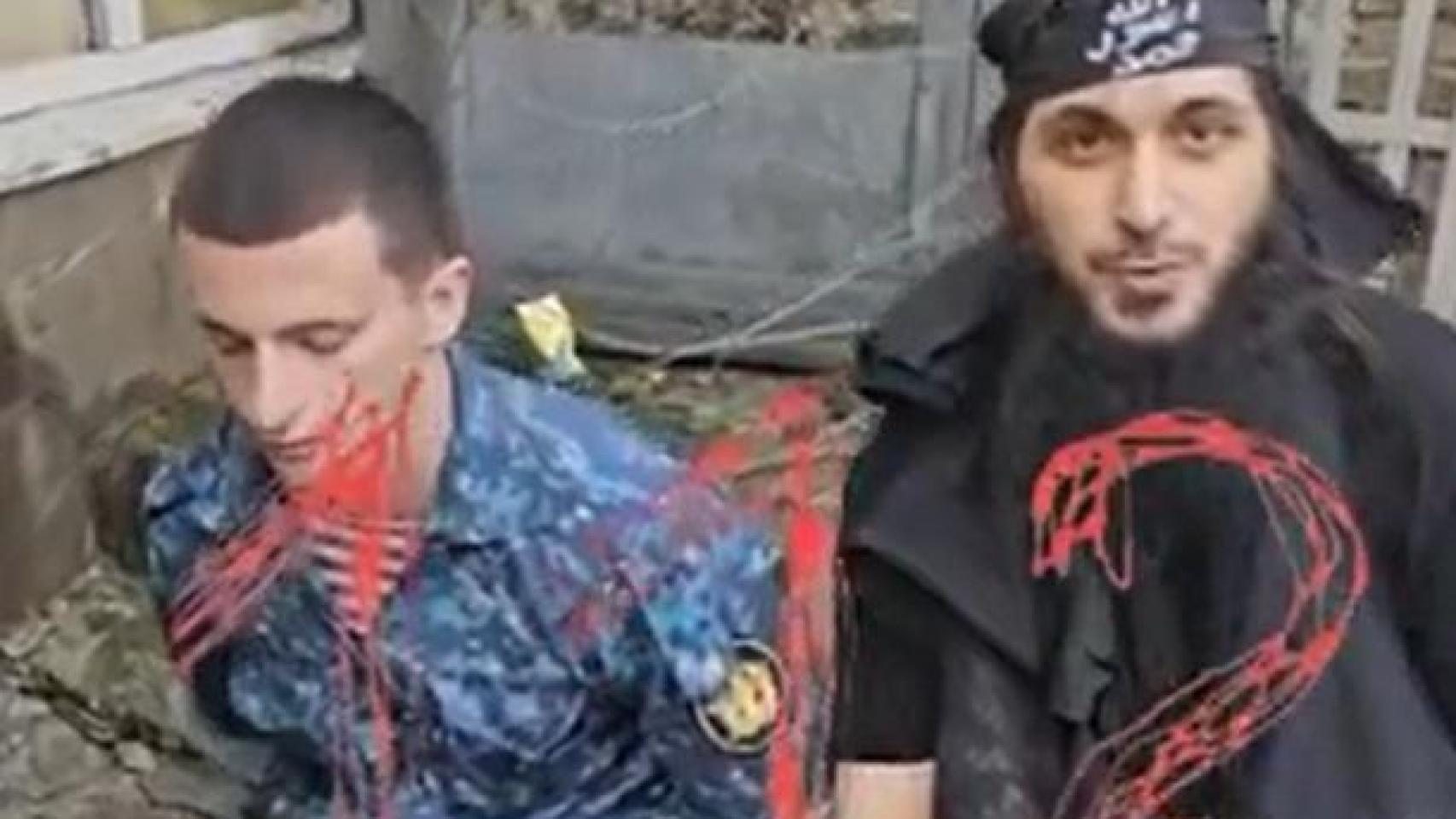 Uno de los presos que se ha proclamado seguidor de ISIS junto a uno de los rehenes.