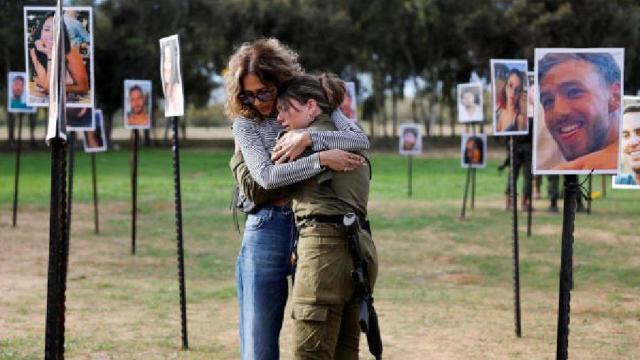 Sigal Manzuri, cuyas hijas, Norelle y Roya, fueron asesinadas en el ataque de Hamas del 7 de octubre en el festival de Nova en Israel, abraza a un amigo de la familia en un homenaje.