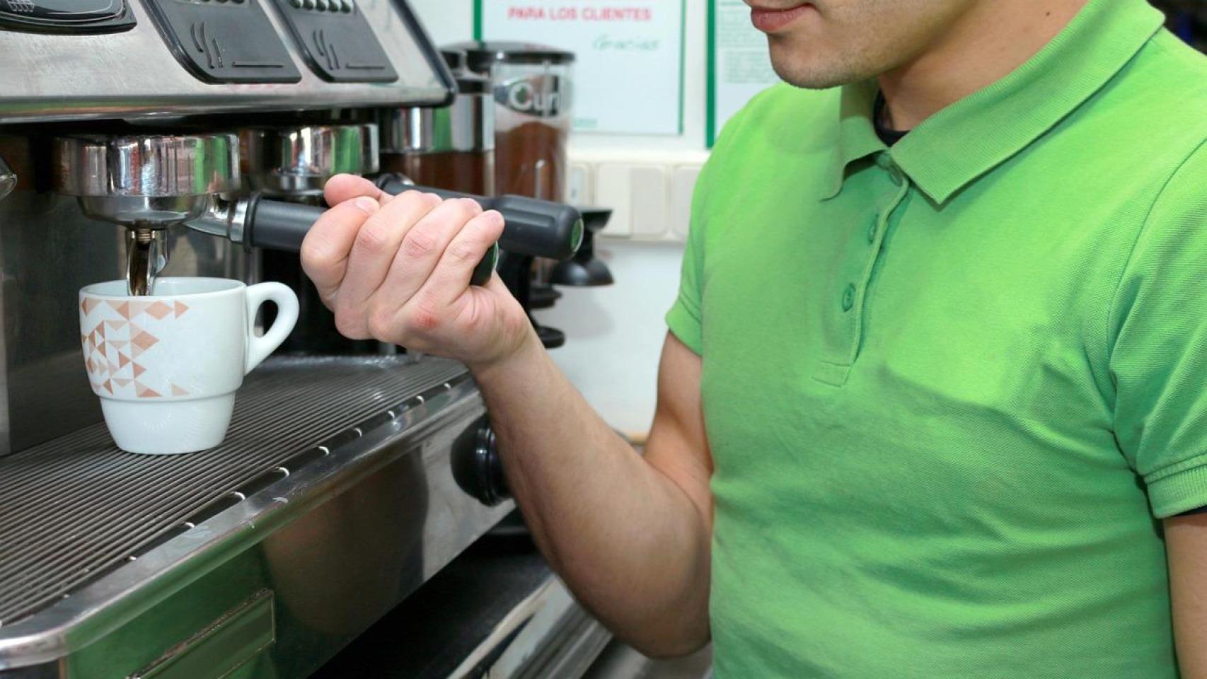 Un trabajador del sector de la hostelería prepara un café.