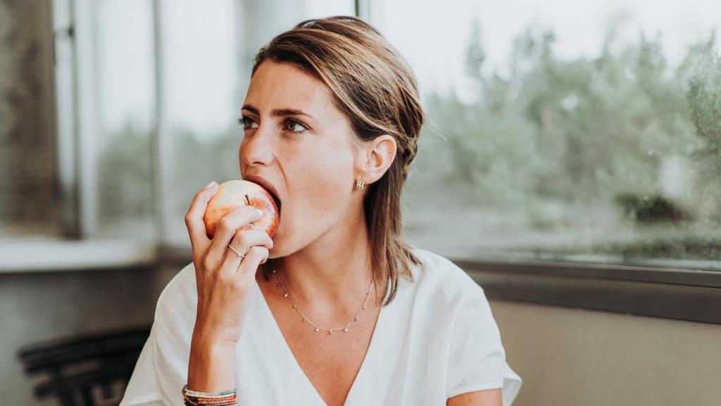 Mujer comiendo una manzana.