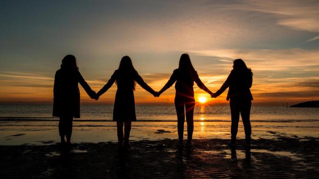 Grupo de cuatro mujeres en una playa.