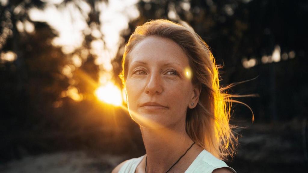 Mujer relajada en un bosque al atardecer.