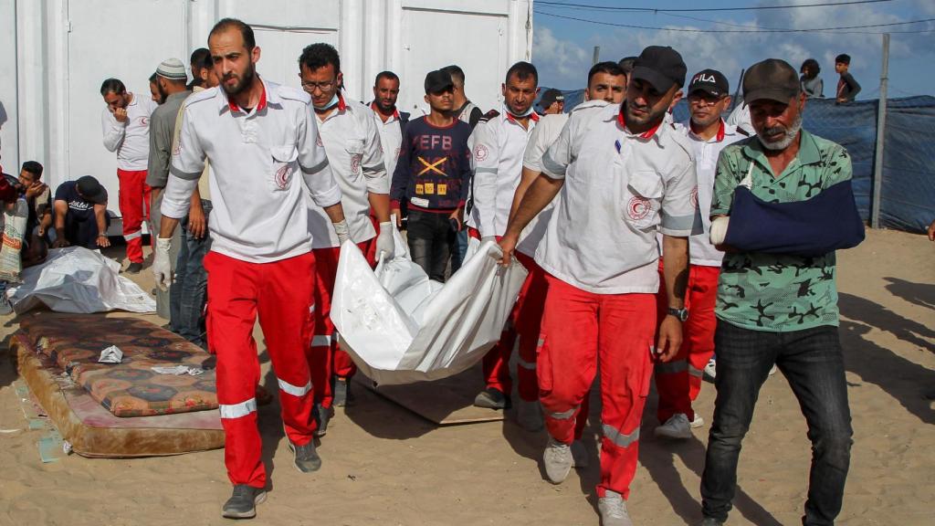 Miembros de la Media Luna Roja Palestina cargan el cuerpo de dos de sus compañeros en Rafah.