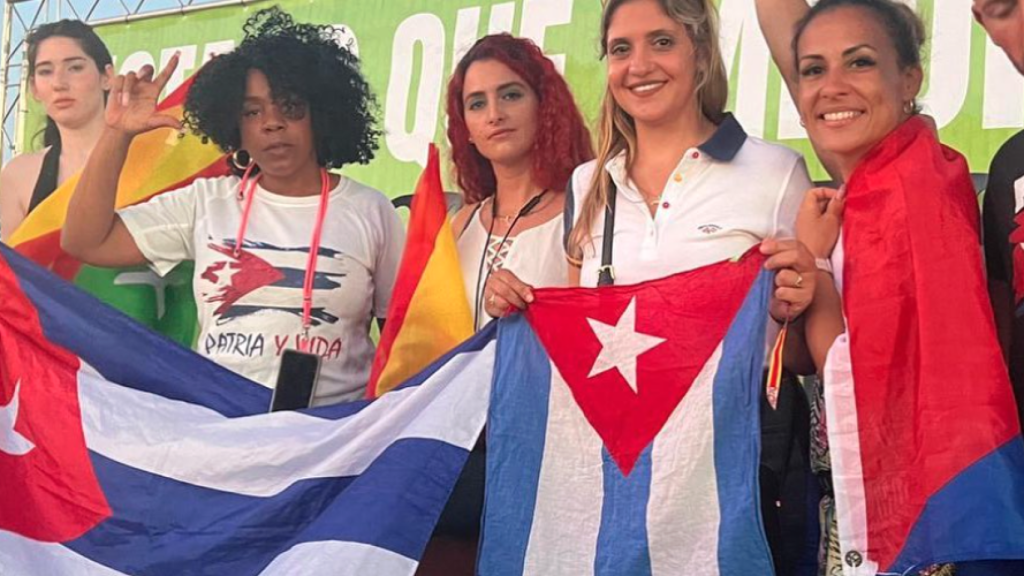 Cuatro cubanas portan banderas del país caribeño en un mitin de Santiago Abascal.