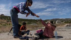 Una trabajadora humanitaria le da comida a dos niños guatemaltecos en Jacumba Hot Springs (California), después de que cruzasen la frontera con México. Adrees Latif Reuters