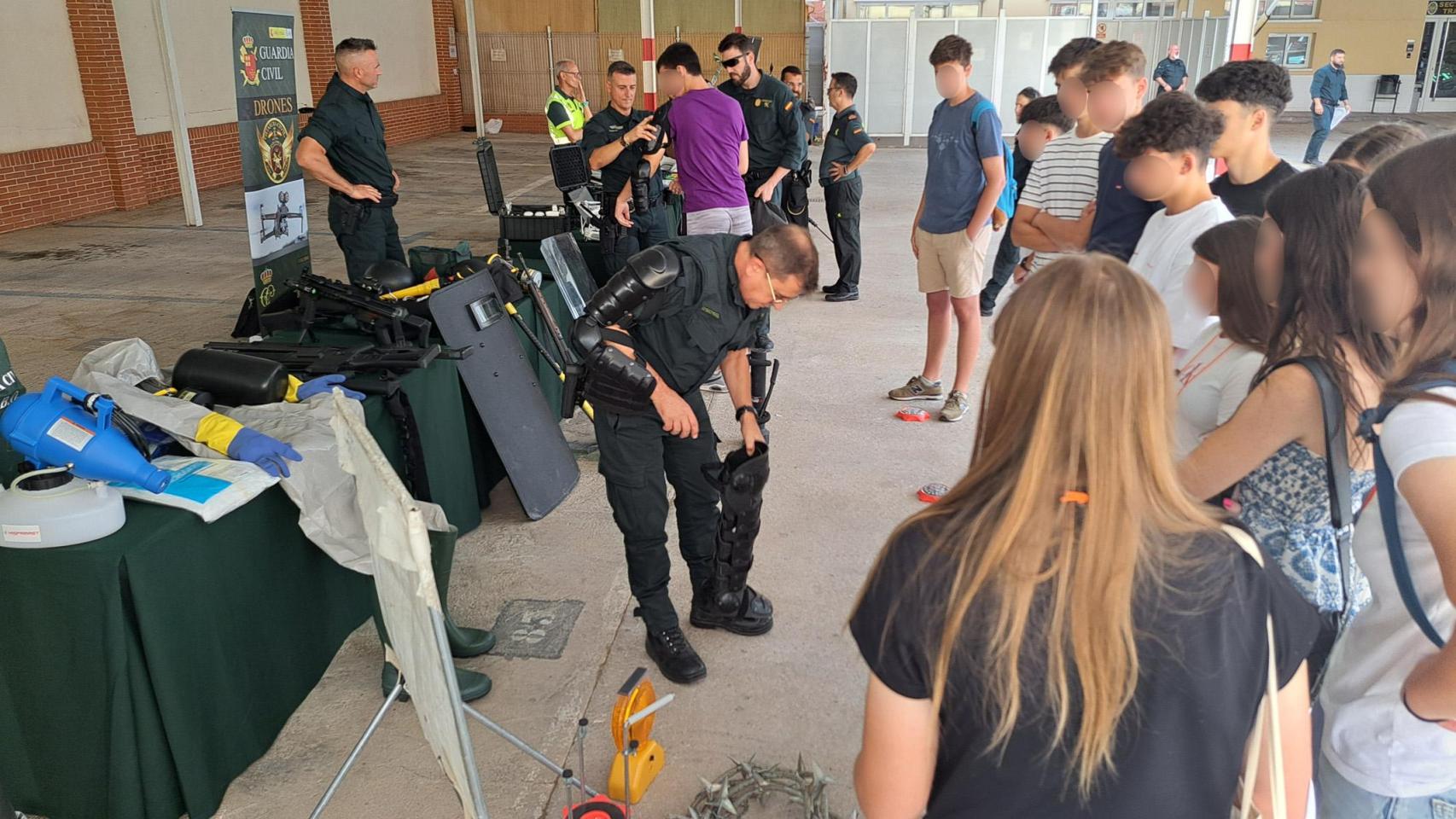 Un agente de la Guardia Civil muestra cómo se pone un traje protector a los alumnos del centro educativo ELIS Murcia.