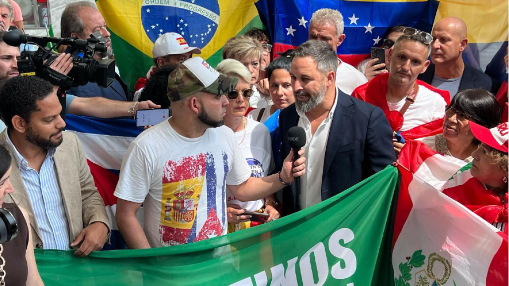 Santiago Abascal, líder de Vox, rodeado de inmigrantes de Latinoamérica que le muestran su apoyo.