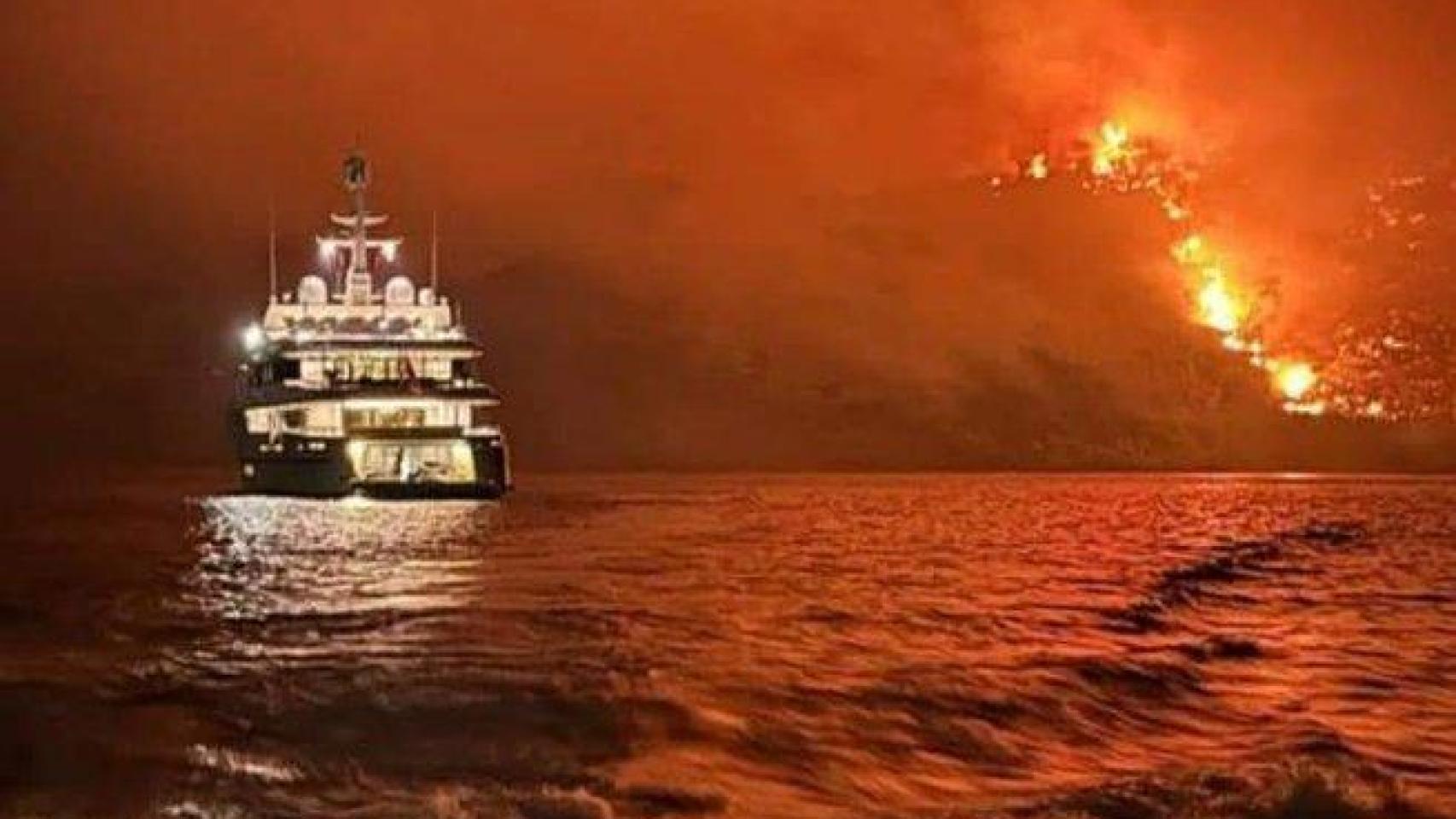El incendio forestal declarado este sábado en la isla griega de Hidra visto desde el mar.