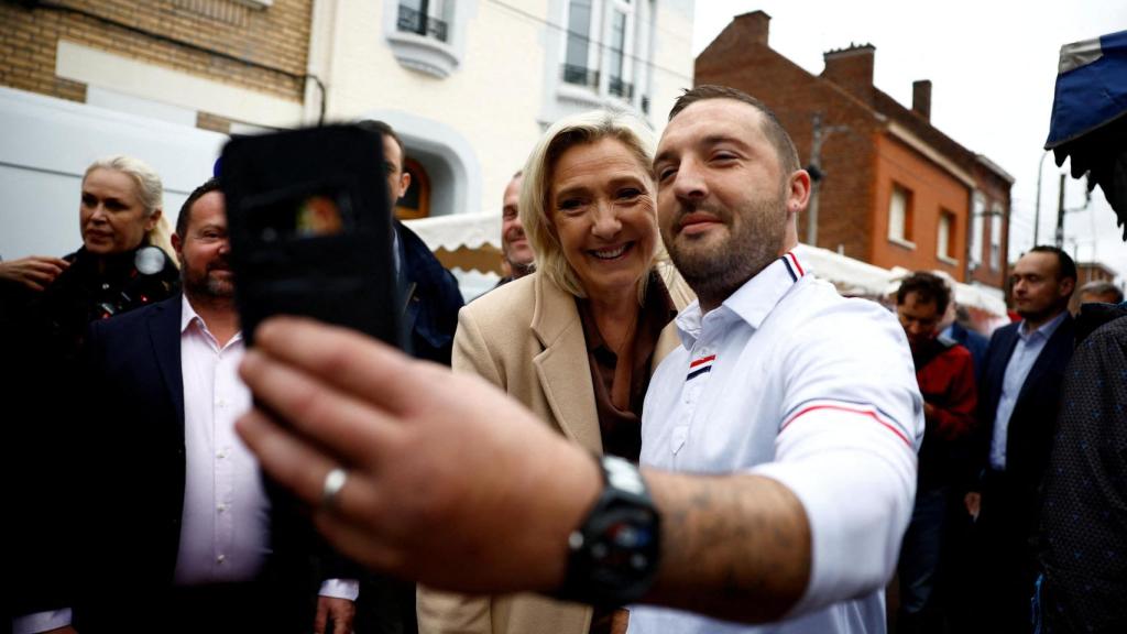 Marine Le Pen, líder de extrema derecha francesa, se hace una foto con un seguidor, en Henin-Beaumont.