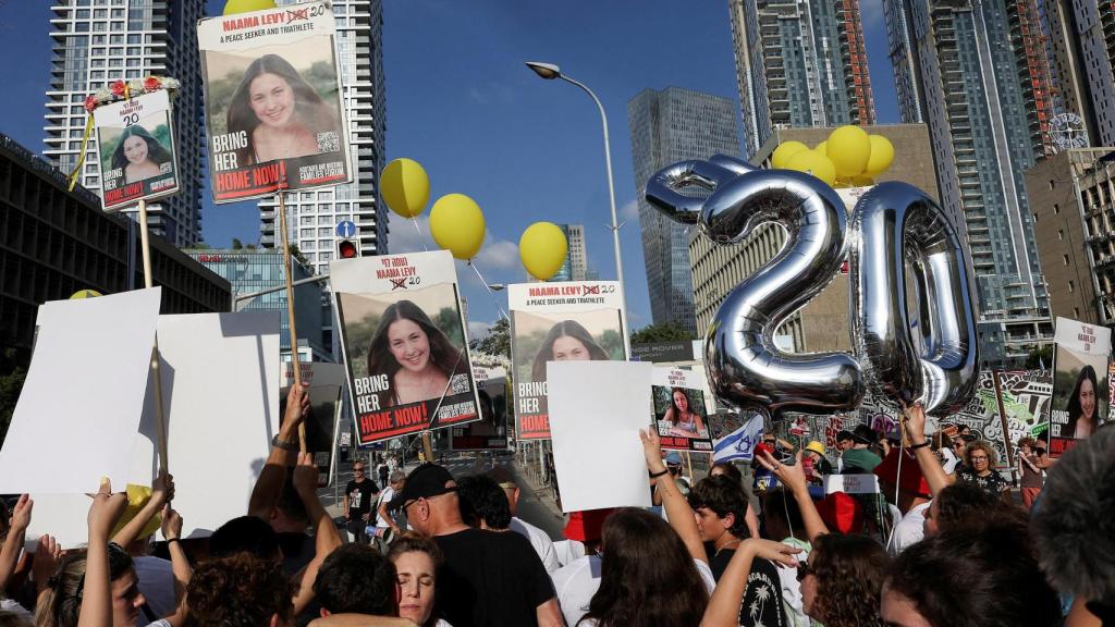 Manifestantes sostienen carteles y globos mientras familiares, amigos y simpatizantes de Naama Levy, una rehén israelí secuestrada durante el mortal ataque del 7 de octubre, asisten a una marcha de protesta en su vigésimo cumpleaños en Tel Aviv.