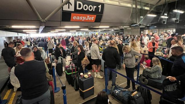 Los pasajeros hacen cola fuera de la Terminal 1 después de que un corte de energía nocturno provocara interrupciones y cancelaciones en el aeropuerto de Manchester en Manchester, Gran Bretaña, el 23 de junio de 2024.