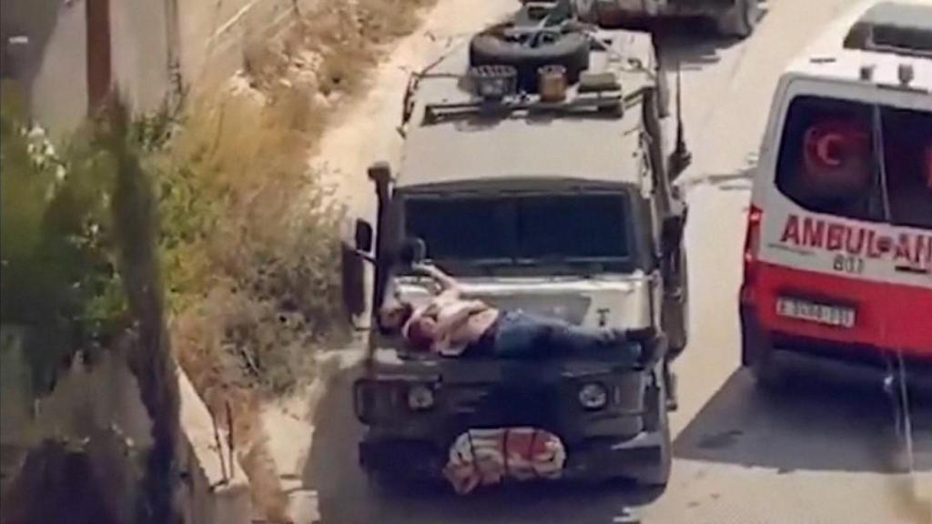 Imagen del palestino herido que fue atado al capó de un vehículo militar por soldados israelíes.