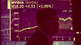 Un trabajador de la Bolsa de Nueva York pasa por delante de una pantalla que muestra la cotización de Nvidia.