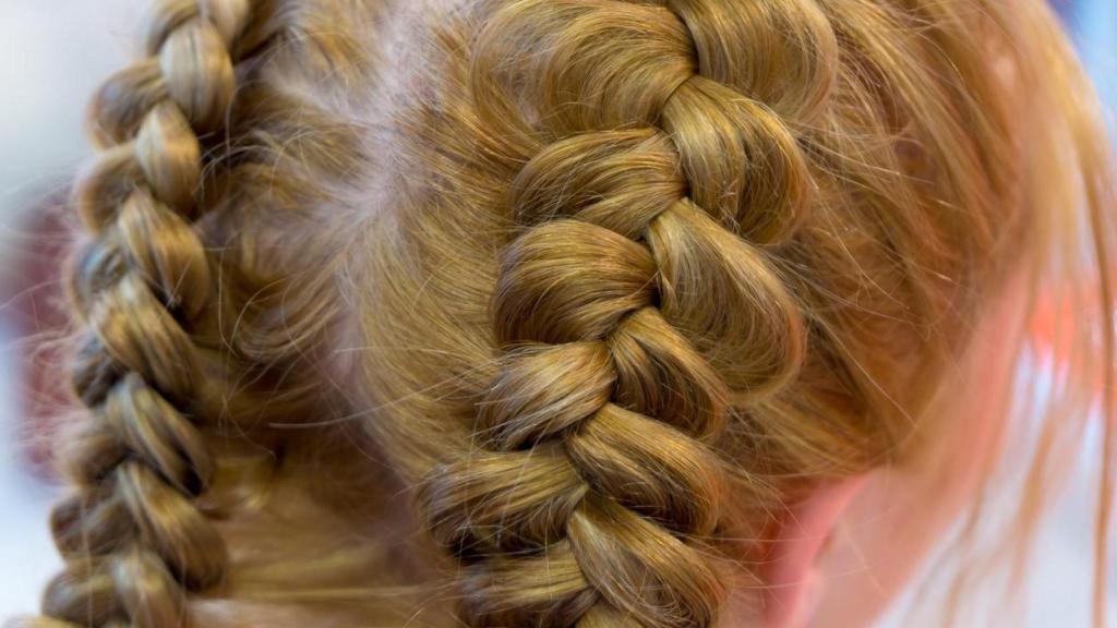 Mujer rubia con dos trenzas de raíz.