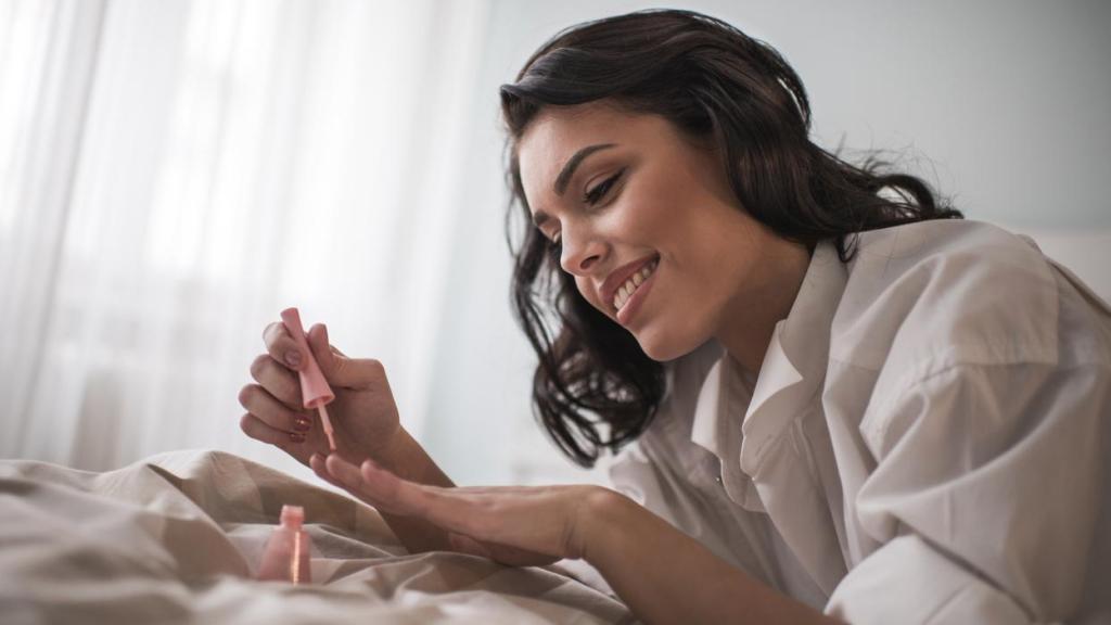 Mujer pintándose las uñas.