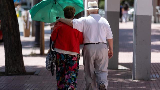 Una pareja de jubilados paseando por la calle.