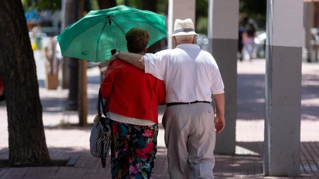 Una pareja de jubilados paseando por la calle.