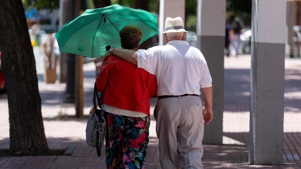 Una pareja de jubilados paseando por la calle.