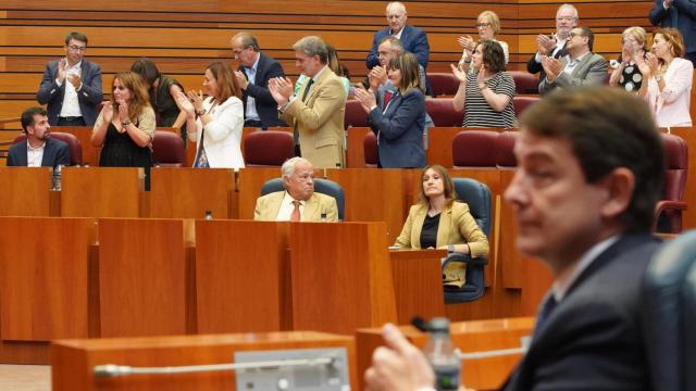 El presidente de la Junta, Alfonso Fernández Mañueco, en primer plano, con la bancada socialista aplaudiendo a su portavoz, Luis Tudanca, al fondo, en el pleno de este miércoles