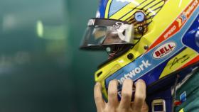 Fernando Alonso colocándose el casco en el box de Aston Martin