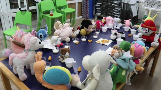 Los peluches desayunan un vaso de leche y una naranja en la biblioteca de Cabanillas del Campo.